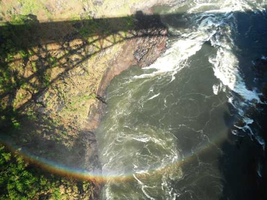 A rainbow shines by the bridge over the Zambezi River on the Zimbabwe side