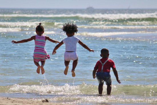 Children jumping in waves in South Africa