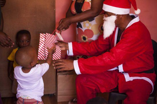 Father Christmas hands out presents to children