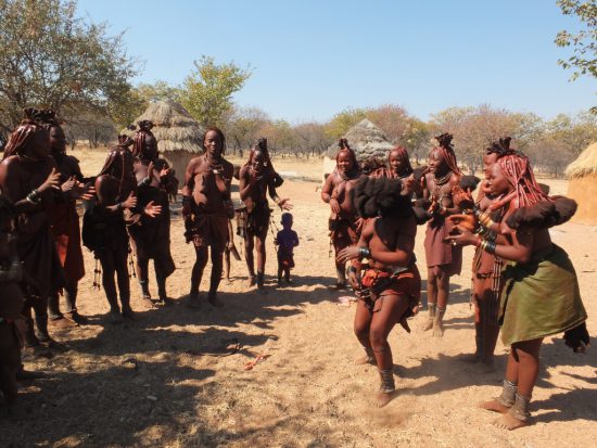 Himba aus Namibia in traditioneller Kleidung beim Tanzen