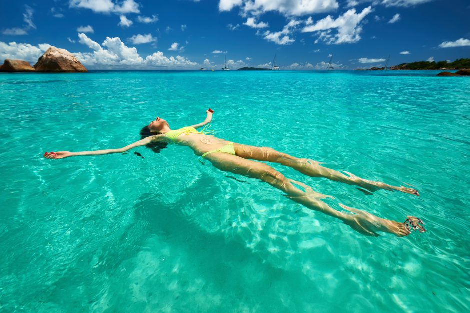 Girl floating in water in the Seychelles