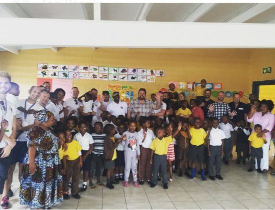 Group photo of kids and IGLTA volunteers