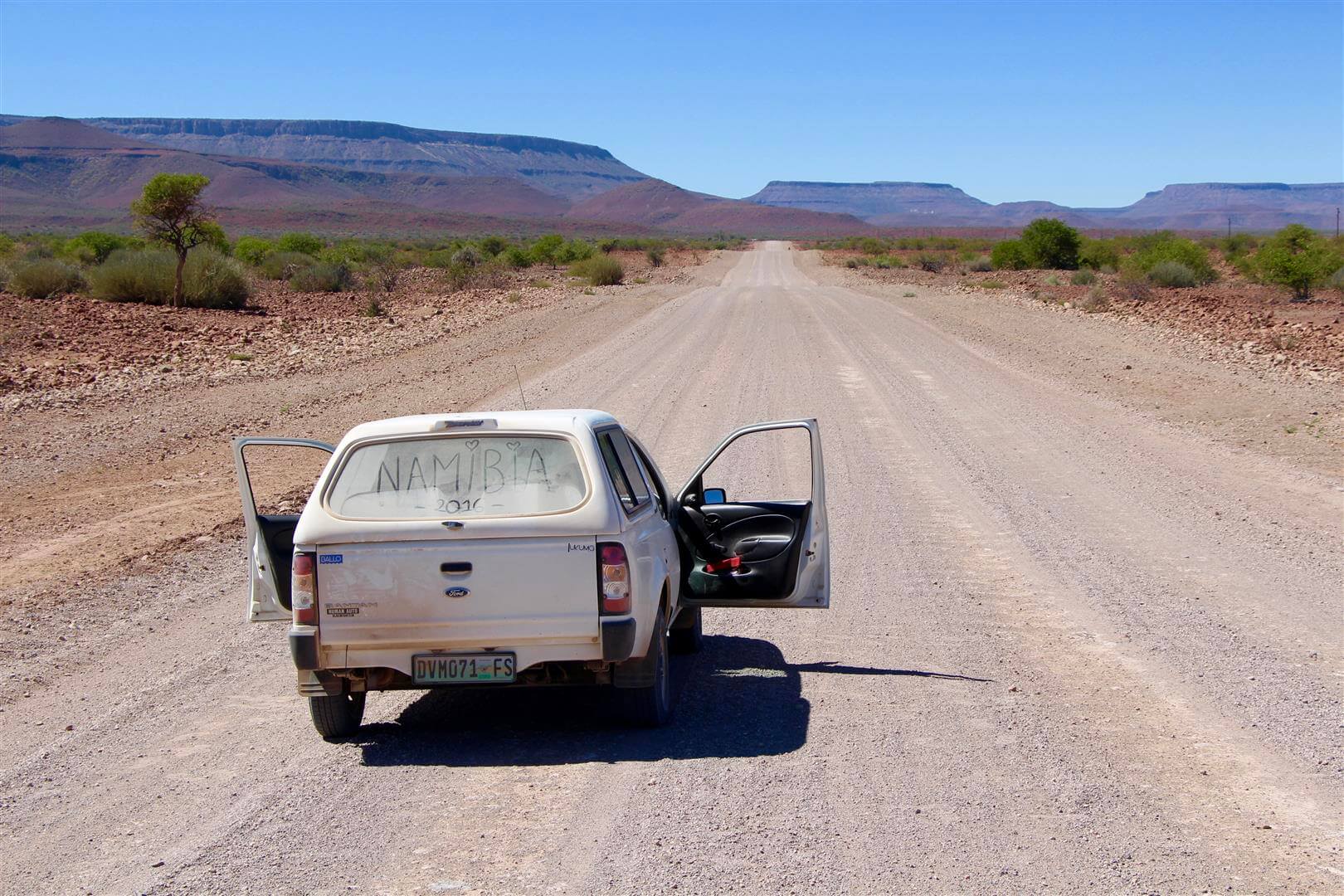 4x4 sur la route entourée par paysage montagneux namib-naukluft namibie