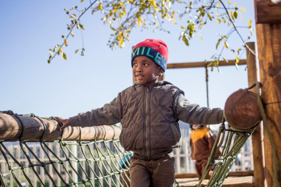 A boy climbs on the new Khumbulani playground