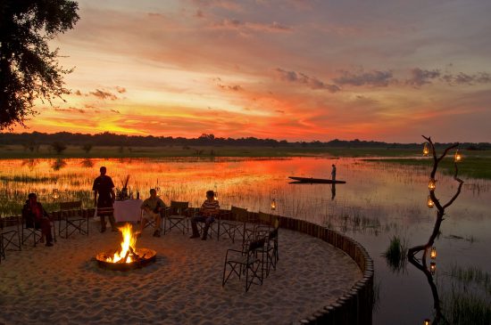 People having drinks next to water round ifre