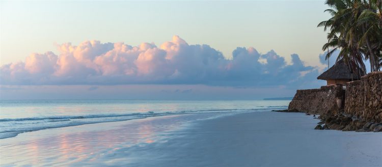 Ein Strand mit Palmen und Wolken in Kenia