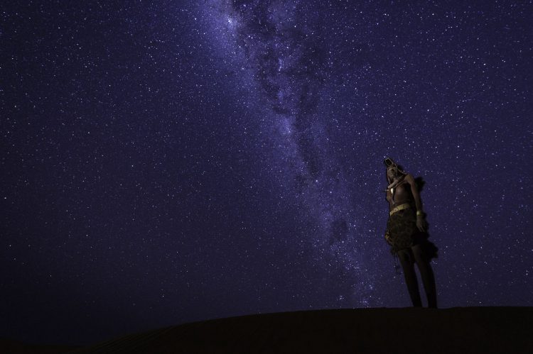 Eine Person starrt in den tiefblauen Sternenhimmel