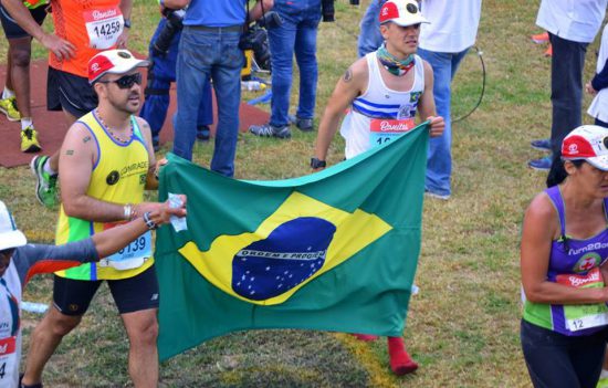 Iago ao final da Comrades Marathon segurando bandeira do Brasil