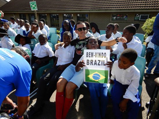 Iago cercado por crianaças da Ethembeni School