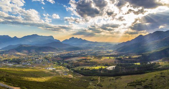 Romantisches Lichtspiel am Himmel über den malerischen Weinbergen von Franschhoek im Kapweinland