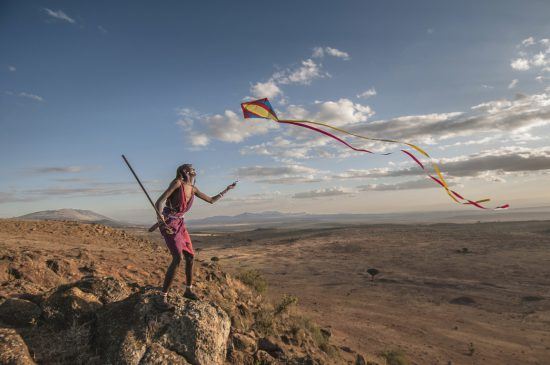 Ein Mann lässt einen Drachen im Rift Valley in Kenia steigen