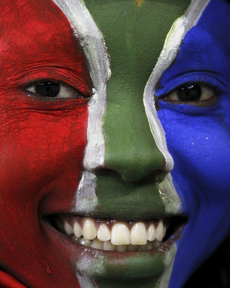 Frau mit Gesichtsbemalung in den Farben der südafrikanischen Flagge