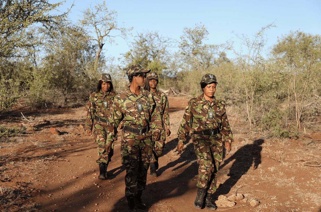 Membros da Black Mamba Unit em uniformes camuflados caminham