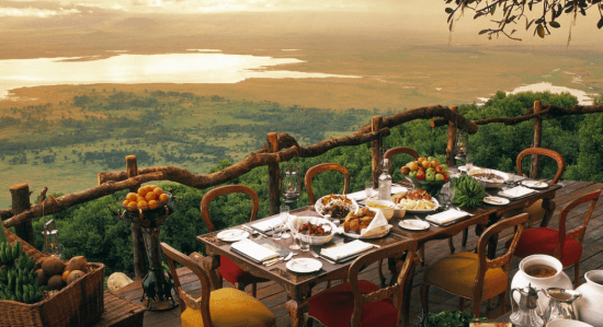 Ein Tisch mit acht Sesseln auf einer hohen Terrasse, dahinter Gewässer und Steppe