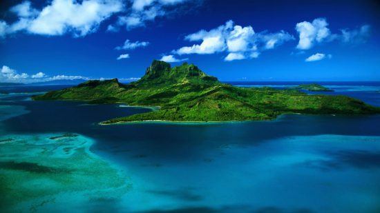 Die grüne Insel Mauritius im dunkelblauen Meer aus der Vogelperspektive