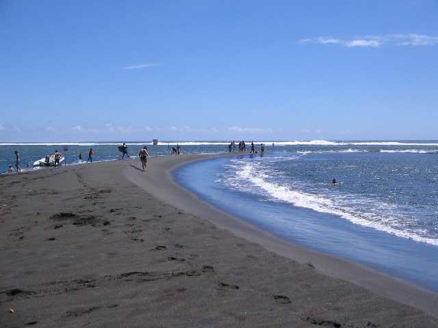 Der schwarze Sandstrand Étang Salé les Bains auf La Réunion