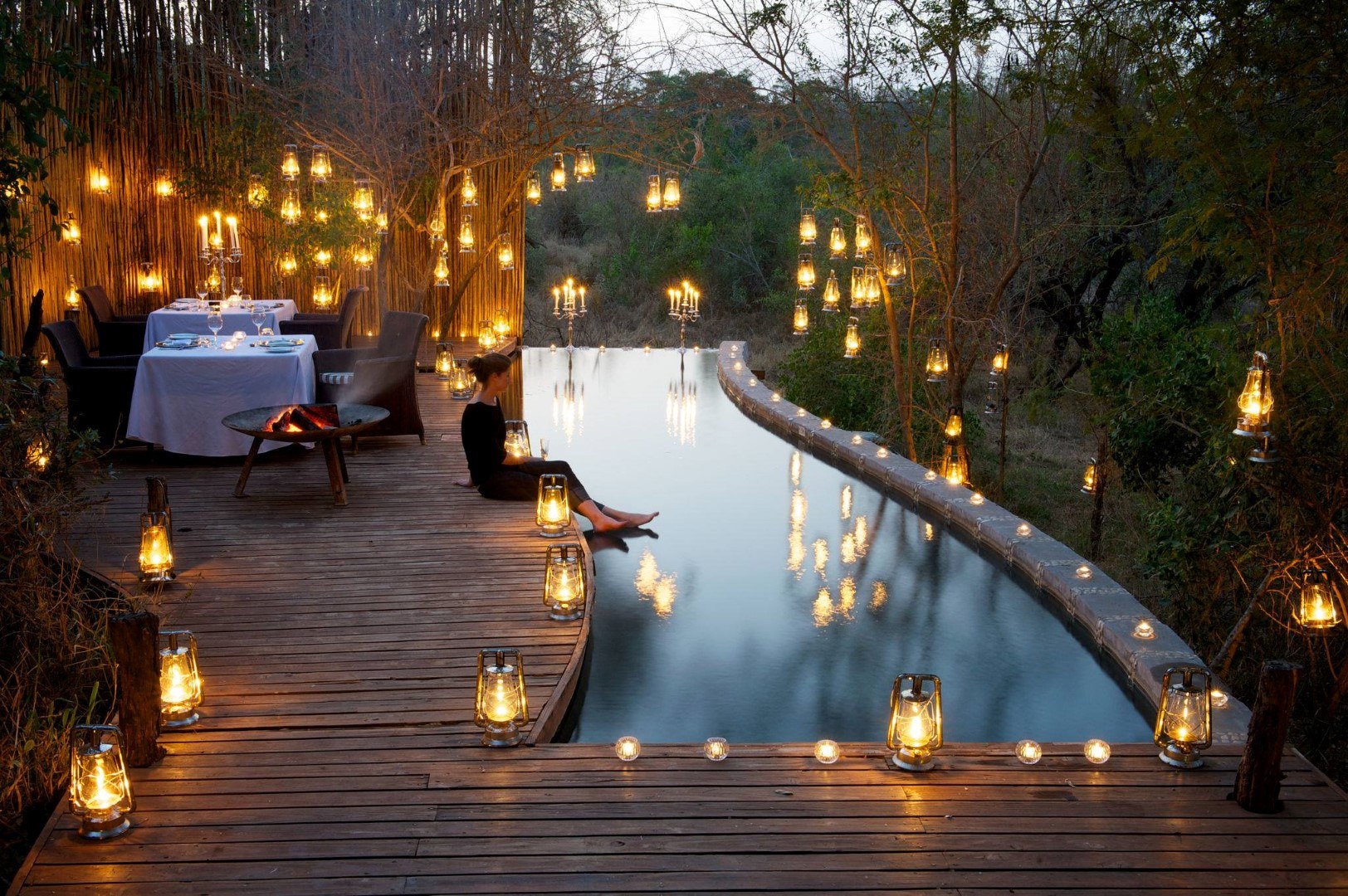 Dîner romantique à la bougie au bord de la piscine en safari à Londolozi, Afrique.