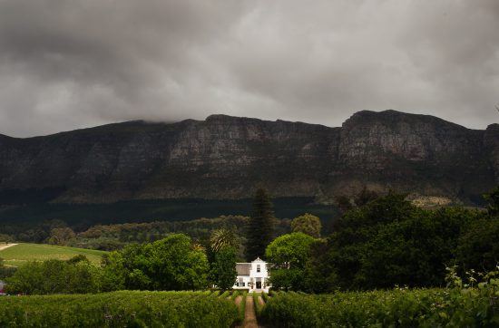 Edifício principal de Buitenverwachting se destaca em dia nublado no Vale de Constantia