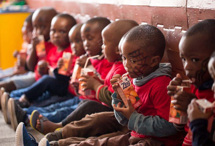 Les enfants pendant une pause goûter à Khumbulani, centre de soin des personnes atteintes du virus VIH.