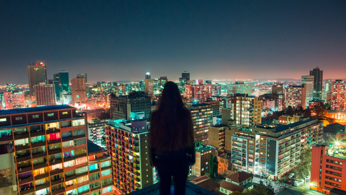 Frau vor Skyline einer Grosstadt bei Nacht