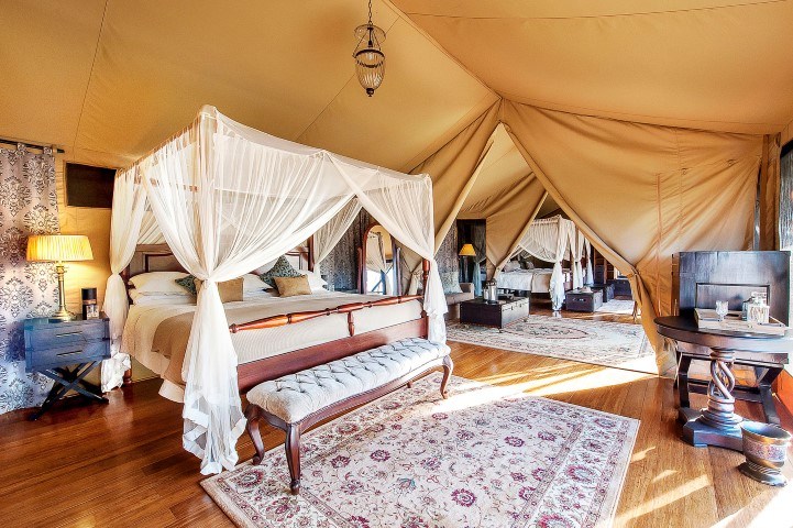 A bed inside a stylish tent at Sand River Masai Masai