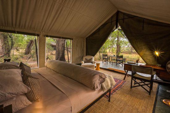 Ein offenes Zelt mit Doppelbett mitten in der Wildnis - die schönsten Unterkünfte in Botswana