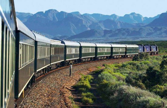 Der grüne Rovos Rail schlängelt sich durch eine malerische Berglandschaft