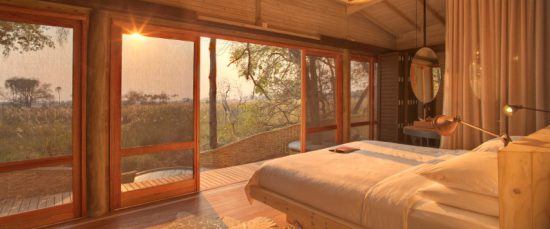 Ein Schlafzimmer der Sandibe Safari Lodge in warmen Tönen