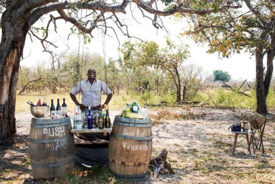 Ein Mann steht hinter einer Bar mitten im afrikanischen Busch - Reiseführer Botswana