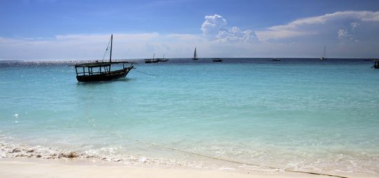 Ein Boot in türkisblauem Wasser vor Sansibar