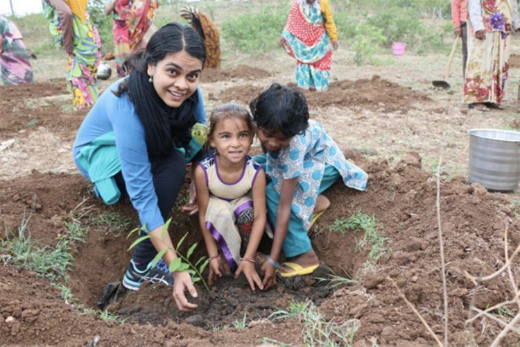 Une femme indienne et ses enfants plantant un arbre en Inde. 