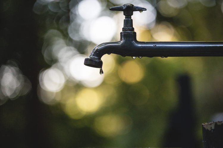 Robinet et quelques gouttes d'eau précieuses dans le contexte de la sécheresse au Cap.