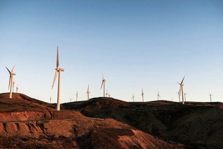 Dizaines d'éoliennes dans la vallée au soleil couchant