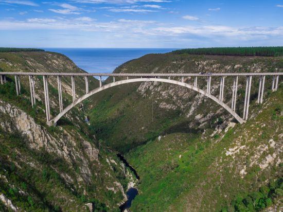 Eine Brücke, darunter führt ein Fluss richtung Meer