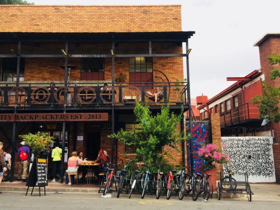 Außenansicht eines Backsteingebäudes mit Cafe und Fahrradständer in Maboneng, Johannesburg