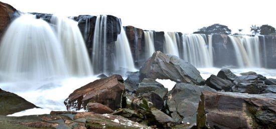 Mehrere Wasserströme fallen in ein felsiges Becken hinab