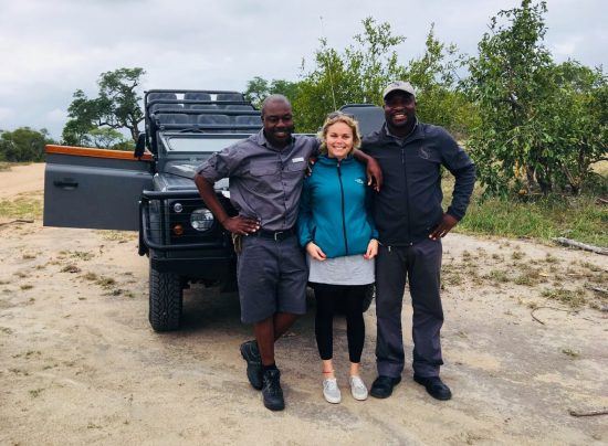 Besucher und Ranger posieren vor dem Geländewagen