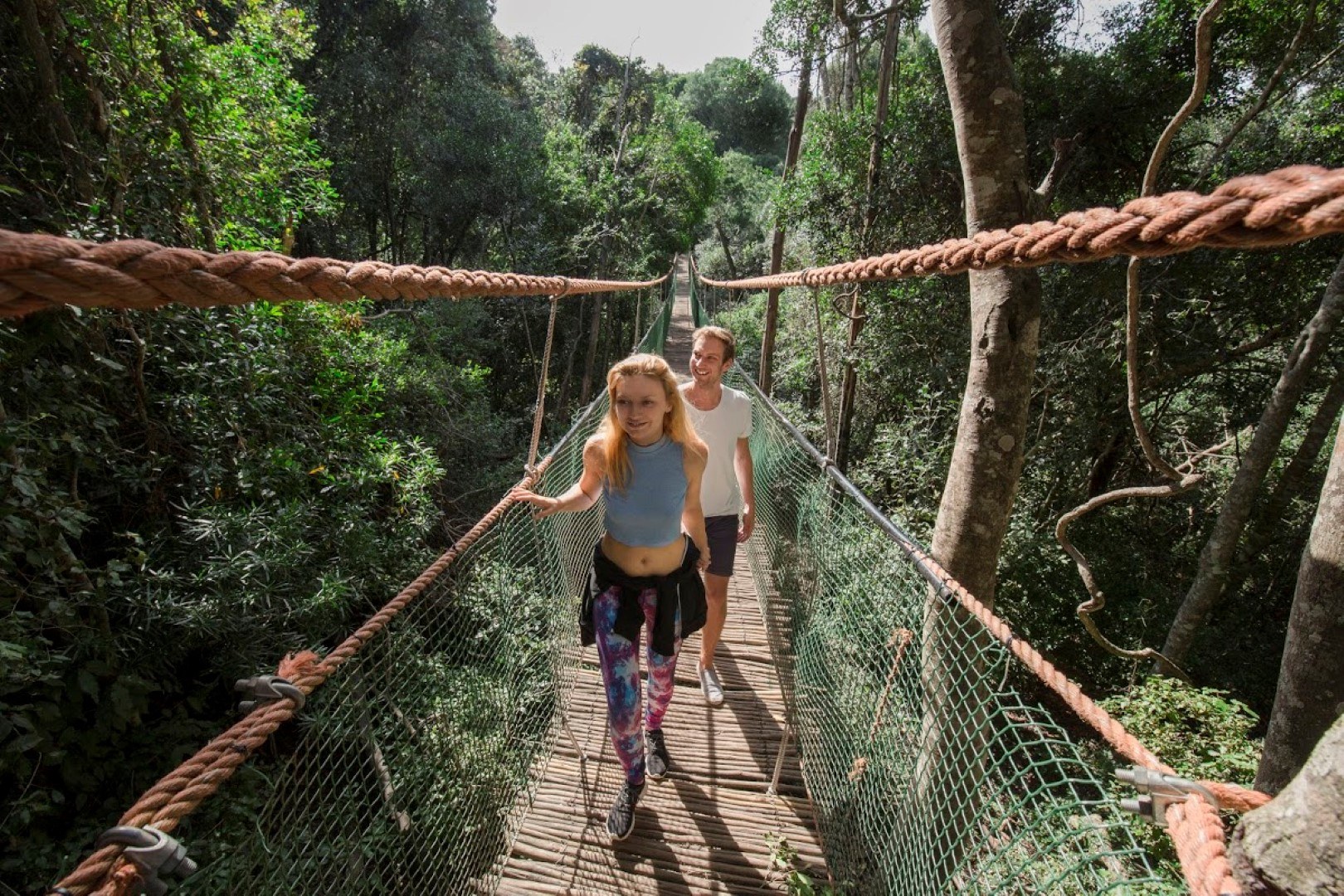 Zwei Personen wandern über eine Hängebrücke