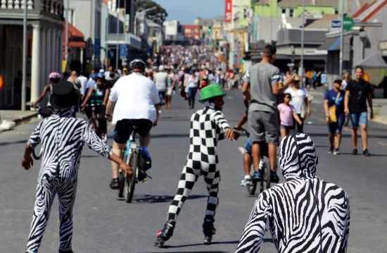 Verkleidete Menschen auf Fahrrädern und Rollschuhen