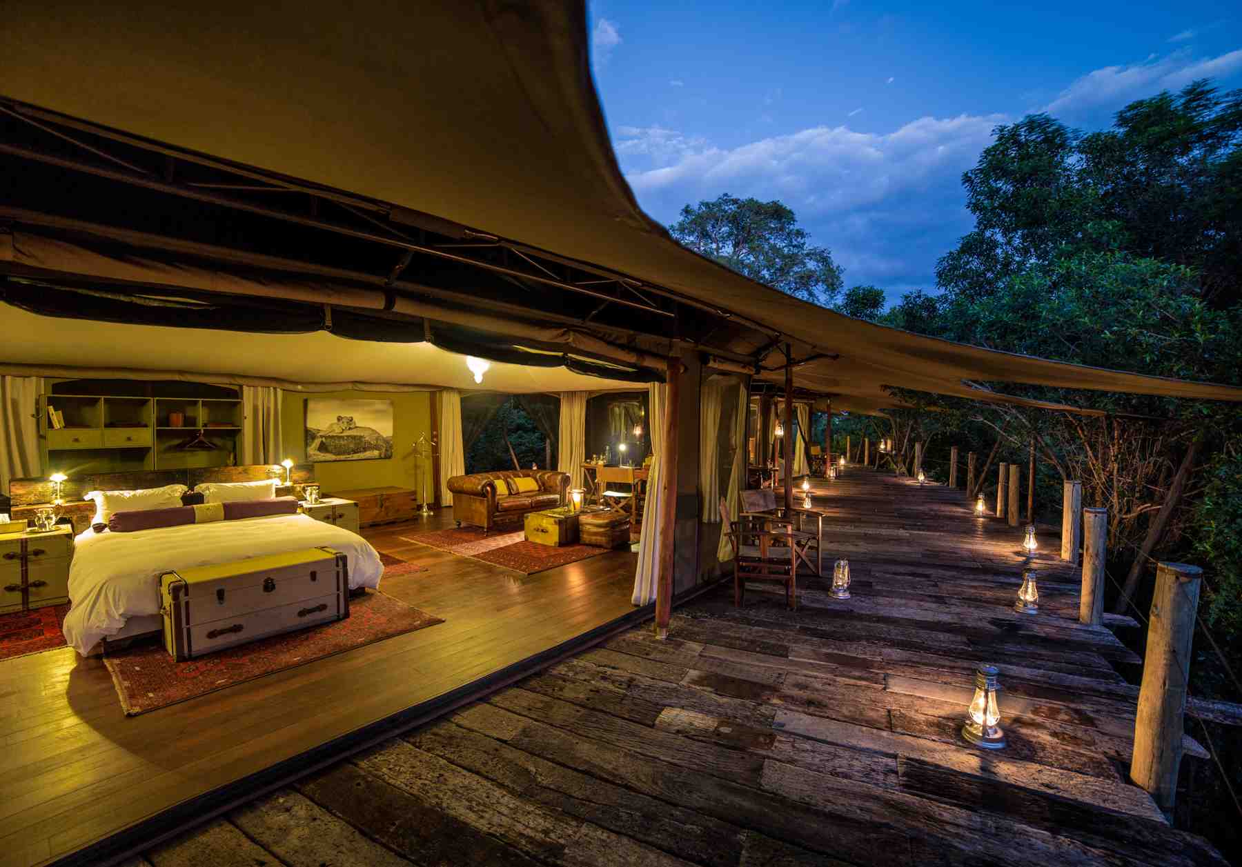 A bedroom with a wooden veranda in the middle of the bush