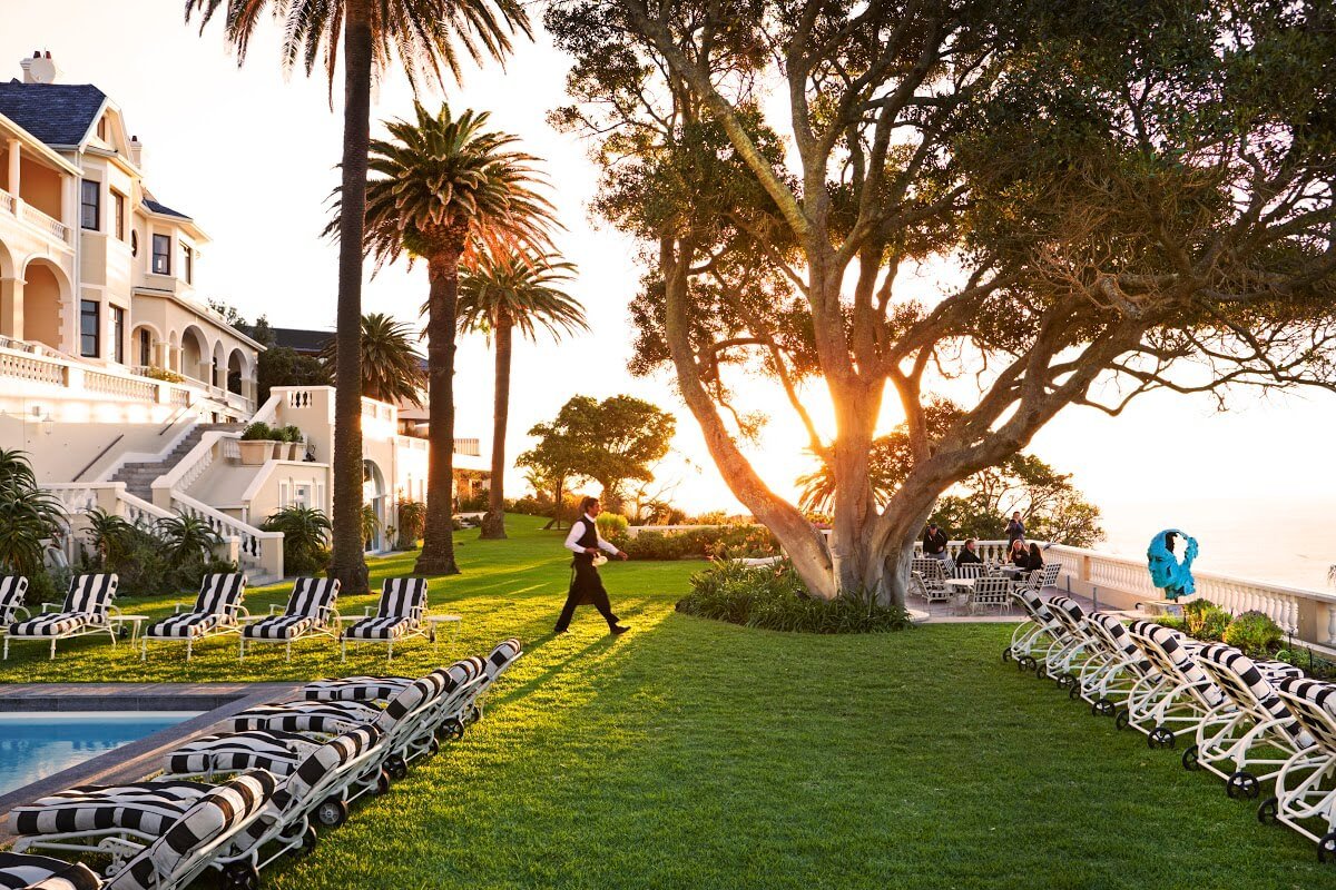 A waiter crosses the lawn in Ellerman House's grounds to serve a guest.