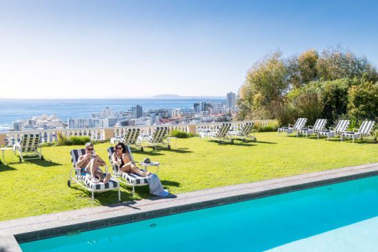 Paar relaxt in Sonnenliegen am Pool des Ellerman House