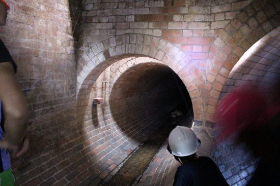 Ein Tunnel in Kapstadt, eine Person mit Helm schaut hinein