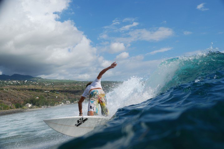 Ein Surfer reitet eine Welle vor der Küste von La Réunion