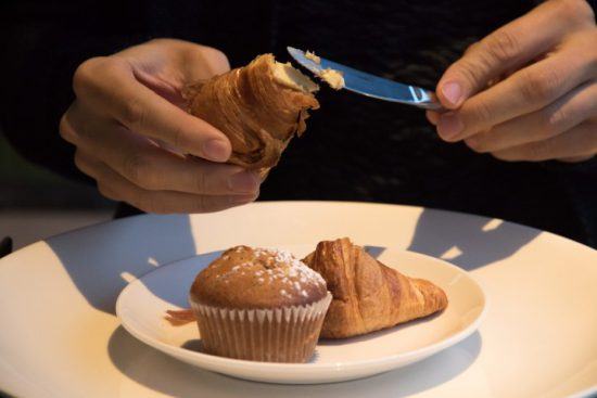 A plate with muffin and croissant