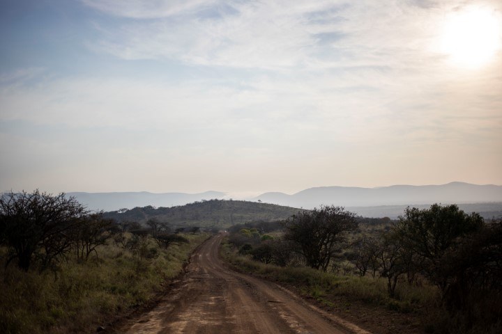 Ein weg führt durch die hügelige Buschlandschaft von KwaZulu-Natal