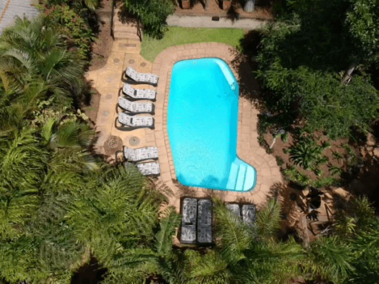 Der Swimmingpool der Lidiko Lodge im tropischen Garten von oben