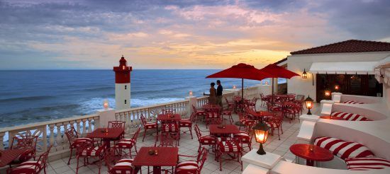 Blick von der Terrasse des Oyster Box Hotel auf einen romantischen Sonnenuntergang sowie einen Leuchtturm