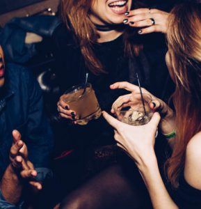 Zwei Frauen mit Drinks in der Hand feiern Silvester