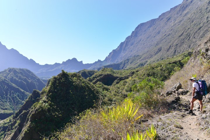 Eine Frau wandert durch die grünen Berge auf La Réunion - erleben Sie die Vulkane auf La Réunion